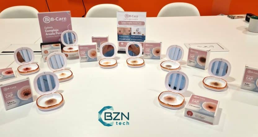 Mesa de exposición en la sede de CEIN con múltiples estuches abiertos de epítesis CAP B-Care, mostrando la variedad de tonos de piel y relieves del complejo areola-pezón.